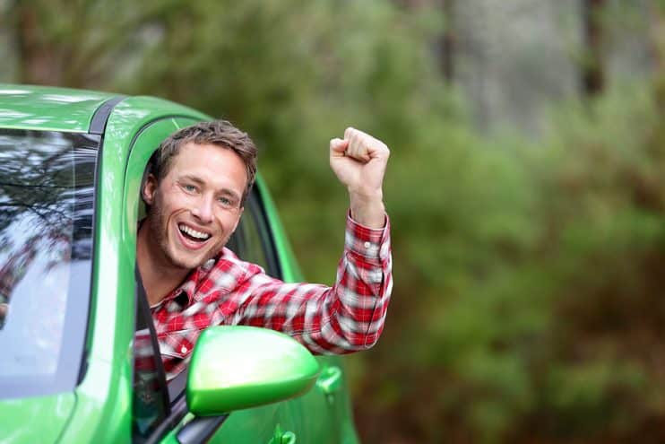 Happy looking person in green car