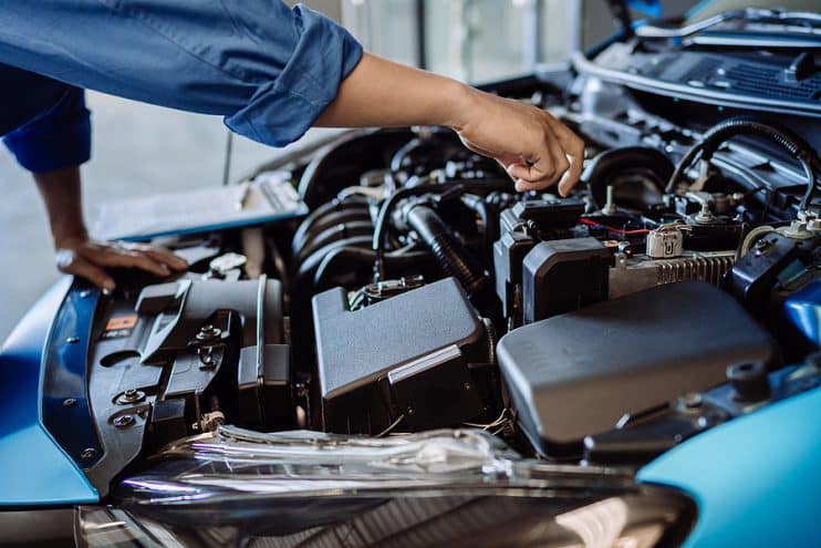 Person inspecting car engine