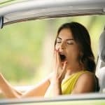 Tired young woman in car