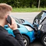 Young Male Motorist Involved In Car Accident Calling Insurance C