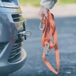 woman assembling towing line to a broken car