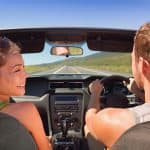 Road trip vacation couple driving convertible car on summer trav