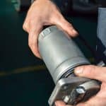 A Car Mechanic Holds A Fuel Filter From A Diesel Internal Combus